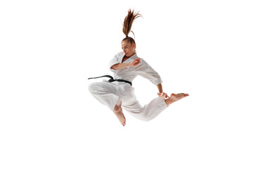 Female karate fighter jumping, training martial arts in action isolated over white studio...
