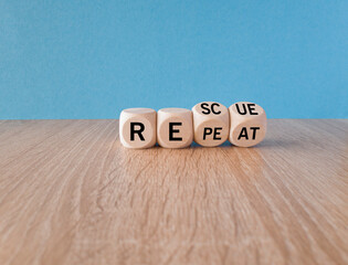 Rescue and repeat symbol. Concept words Rescue Repeat on wooden cubes. Beautiful wooden table blue...