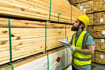 Beard man wood  worker checking stock of woods in contribution warehouse