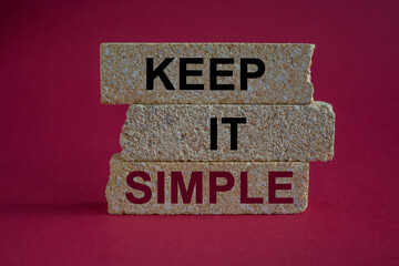 Keep it simple symbol. Concept red word Keep it simple on beautiful brick blocks. Beautiful red background. Business motivational keep it simple concept. Copy space.