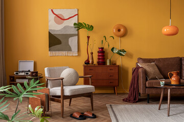 Creative composition of cozy living room interior with wooden sideboard, coffee table, brown sofa, yellow wall, kilim rug, orange lamp, vase with leaves and personal accessories. Home decor. Template.