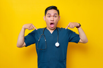 Surprised professional young Asian male doctor or nurse wearing a blue uniform standing confident...