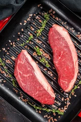 Fotobehang Raw Cap Rump steak, marbled beef meat on a grill skillet. Dark background. Top view © Vladimir
