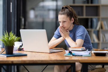 Portrait of tired young business Canada woman work with documents tax laptop computer in office....