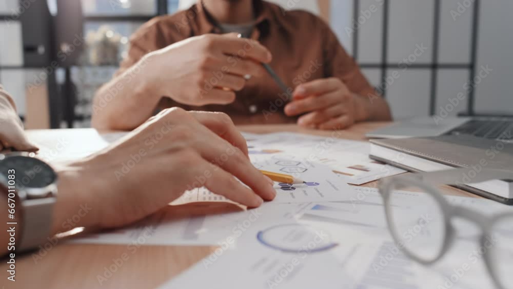 Poster close up stab shot of two unrecognizable business partners in casual wear negotiating chart data poi
