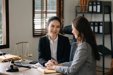 Business people compassionately holding hands and discussing contract papers with laptop and tabletat office .