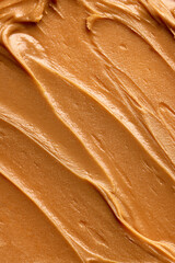 Close-up of peanut butter with smooth, creamy texture. Light brown color with few small swirls....