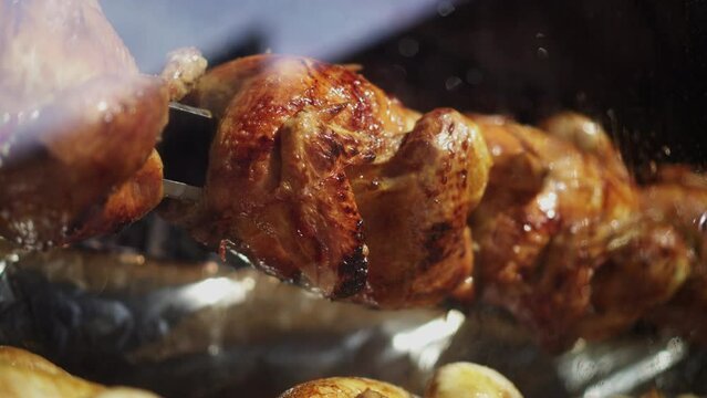 Primer plano de un pollo asado cocin&aacute;ndose en una barbacoa a fuego lento