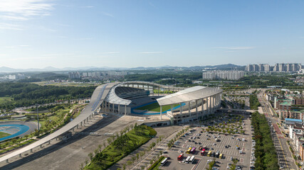 Aerial top view of a natural grass football field and running track