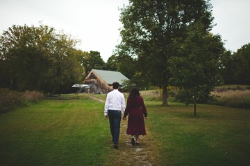 a man and a woman walking down a path towards a giraffe