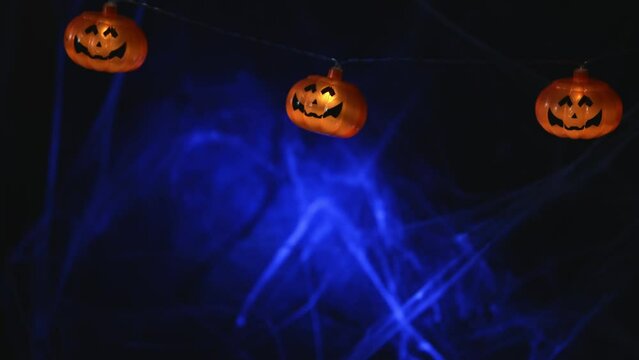 Garland with orange pumpkins on the background of cobwebs. with copy space. Halloween card background