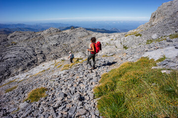 Fototapeta premium hiker advancing through the limestone relief of the Arres de Anie, Anie peak, Larra limestone plateau, Navarrese-French Pyrenees, Navarra, Spain