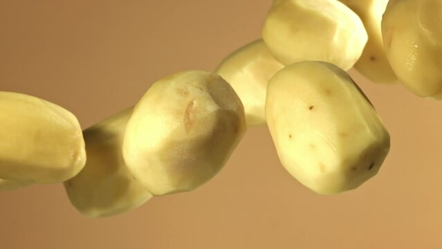 Peeled potatoes fly up and fall down. Filmed on a high-speed camera at 1000 fps. High quality FullHD footage