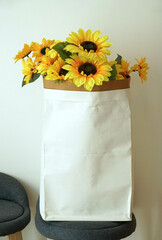 artificial sunflower In an empty paper bag for storing content, Place on a chair for a vintage style home or shop decoration.