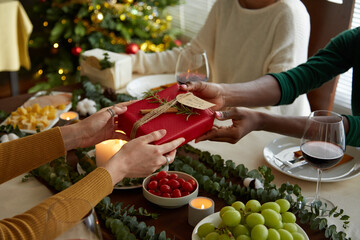 Friends exchanging gifts at Christmas celebration party at home