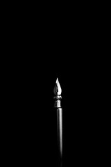 an ink pen with a metal tip close-up on a black background. classic fountain pen isolated macro...