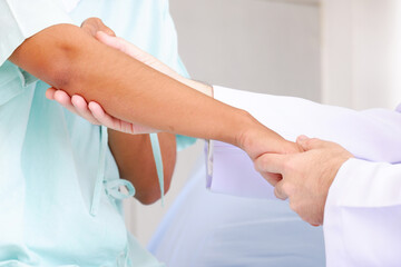 Doctor examining patient in arm.