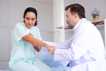 Fototapeta premium Doctor with patient lying on bed in exam room.
