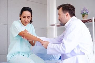 Fototapeta premium Doctor with patient lying on bed in exam room.