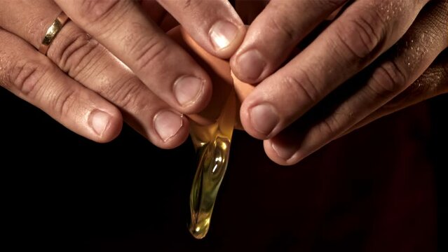 A raw egg falls from a man's hands. Filmed on a high-speed camera at 1000 fps. High quality FullHD footage