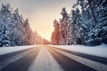 Beautiful view of the sunset in the evening on the country snowy road.