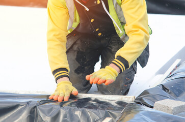 Installation of sheet of expanded polystyrene under concrete floor for house thermal insulation...