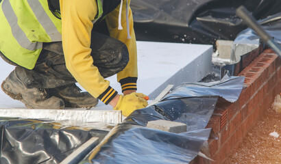 Installation of sheet of expanded polystyrene under concrete floor for house thermal insulation...