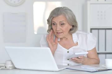 old woman with a laptop on a white background