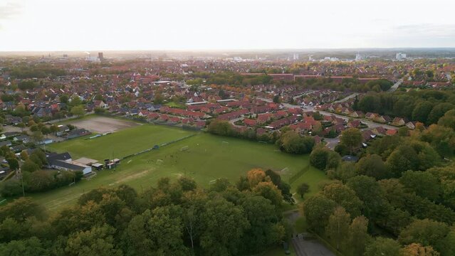 Aerial view of forest, football fields and city