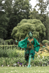A mystical green dryad in the forest in the background. A fabulous mythical creature