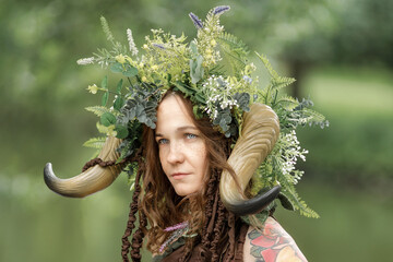 A pretty young faun in the woods. Mythological forest creature at the tree - obrazy, fototapety, plakaty