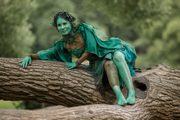 A mystical green dryad in the forest in the background. A fabulous mythical creature.