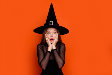 Photo portrait of pretty blonde teenager girl terrified reaction dressed black halloween outfit isolated on orange color background