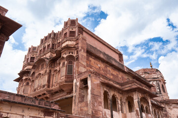 Obraz premium Look up at the red and yellow castle standing majestically on the hill. Mehrangarh Fort is in Jodhpur, Rajasthan, India. UNESCO World Heritage Site.