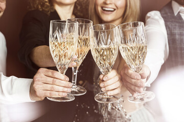 Group of elegantly dressed people celebrating a holiday or event, drinking sparkling wine