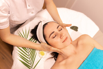 Fototapeta na wymiar Beautiful woman in spa salon getting face massage treatment. Girl facial treatment. Skin care. Body care.