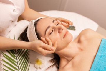 Beautiful woman in spa salon getting face massage treatment. Girl facial treatment. Skin care. Body care.