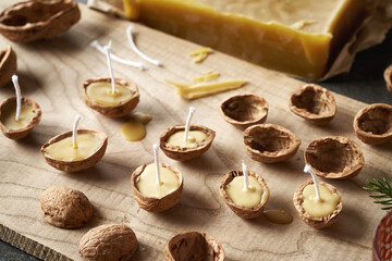 Preparation of handmade Christmas candles from beeswax, wick and walnut shells