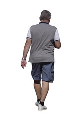 Homme de 60 ans marchant en été, vu de dos, polo gris et blanc, bermuda bleu et baskets blanches,...