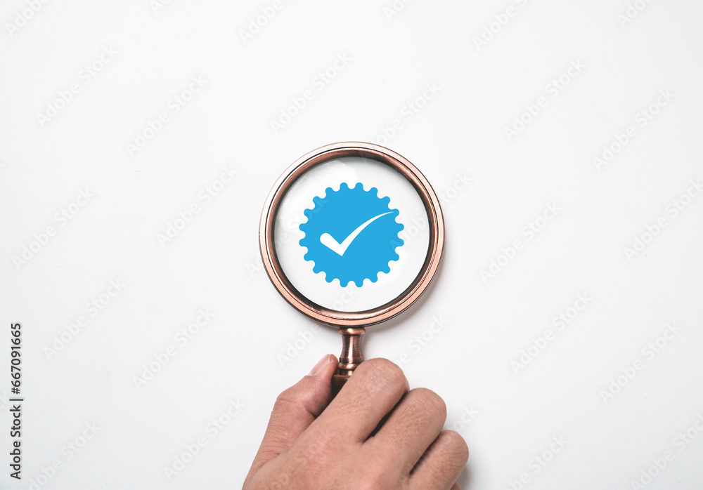 Poster Hand holding magnifier glass with correct sign mark on white background for document approval of quality control assurance and accept project concept.