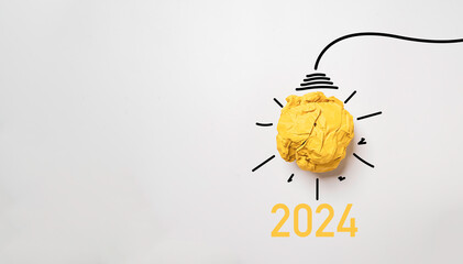 Yellow scrap paper ball for virtual lightbulb with 2024 on white background for creative thinking innovation and problem solving in new year concept.
