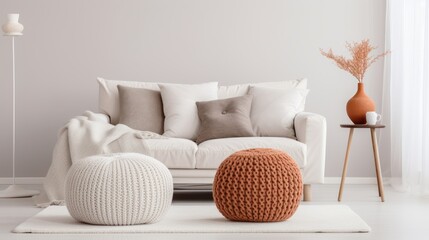 Fototapeta na wymiar White sofa with plaid and cushions on knitted rug on wall background. modern living room. Mockup living room