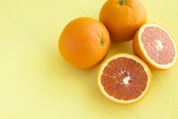 Four Oranges on yellow backgrounds