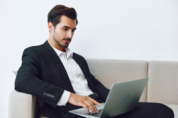 Man in office businessman sitting at desk and working in laptop and talking on phone, modern suit, finance and startup concept and data analysis, working lifestyle in bright office.