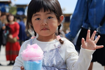 お祭りで綿菓子を食べる子供