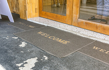Welcome mat in shop front of door. - obrazy, fototapety, plakaty