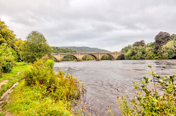 Dunkeld, Scotland - September 25, 2023: The ancient bridge over the Tay River in Dunkeld, Scotland
