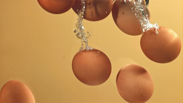 Eggs fall under water with bubbles. Filmed on a high-speed camera at 1000 fps. High quality FullHD footage