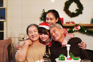 Portrait of asian happy family celebration in christmas day, sitting the dining room at home. look...