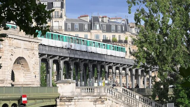 The parisian urban subway (MP 73 metro, metropolitain) passes over a bridge (pont de Bir-Hakeim Passy MP73 line 6) with Haussmann-style buildings in the background in the French capital, Paris, France